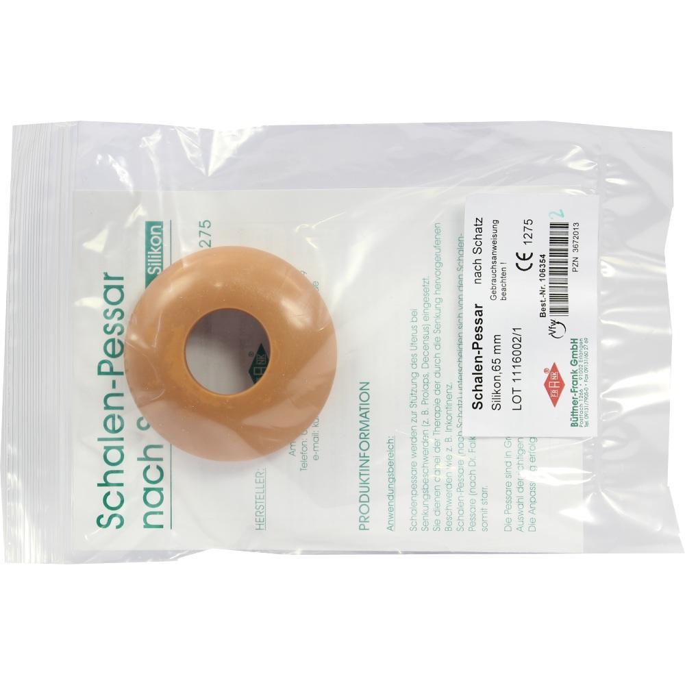 Ein rundes, bräunliches Medizingerät liegt auf einer Verpackung.