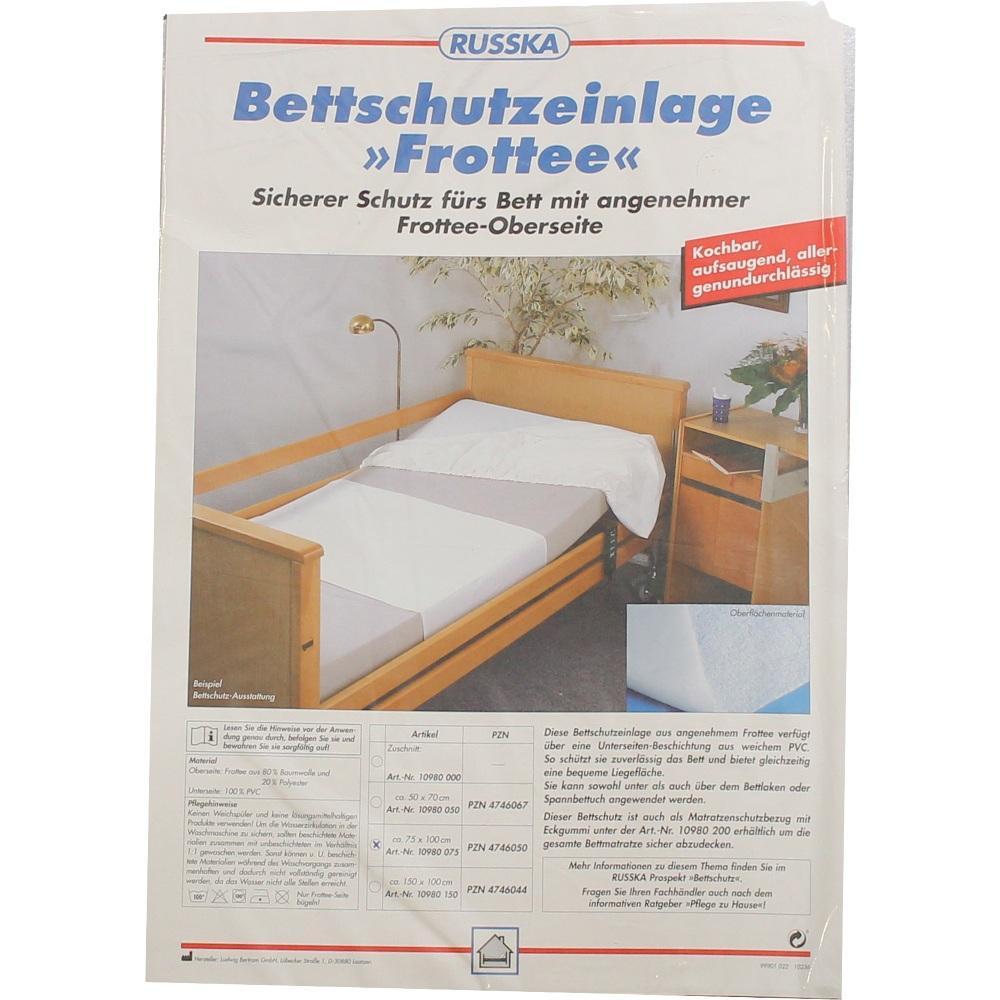 Eine Bettschutzauflage aus Frottee auf einem Holzbett.