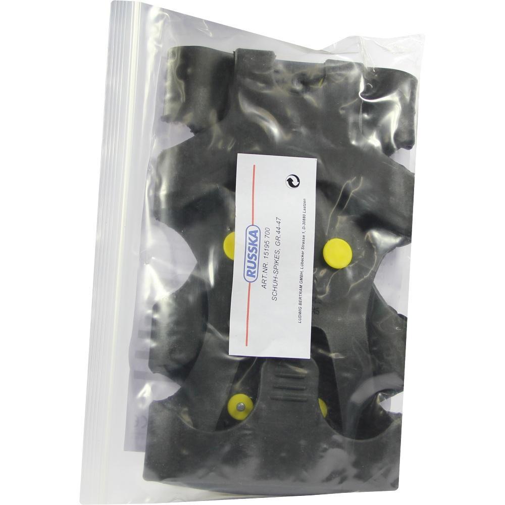 Schwarze Schuhspikes mit gelben Noppen in einer durchsichtigen Plastikverpackung.