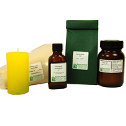 Gelbe Kerze und braune Flaschen mit einem gr&uuml;nen Paket dahinter.