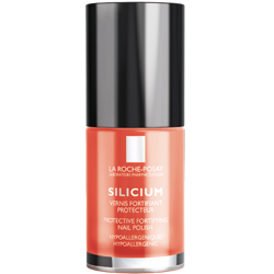 Ein orangefarbener Nagellack mit schwarzem Deckel steht aufrecht.